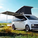 A photo of the Hyundai Staria Lounge Camper concept with its roof popped and awning out.